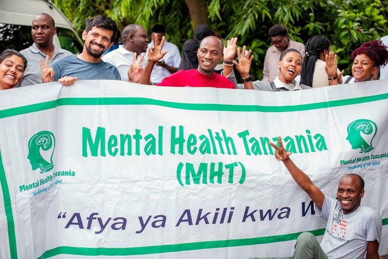MHT team holding an Afya ya Akili kwa Wote banner